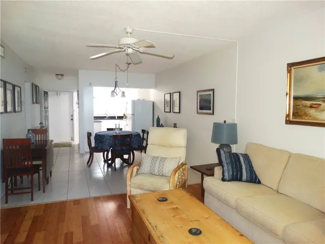 a large bed sitting in a bedroom next to a window with a table and a chandelier