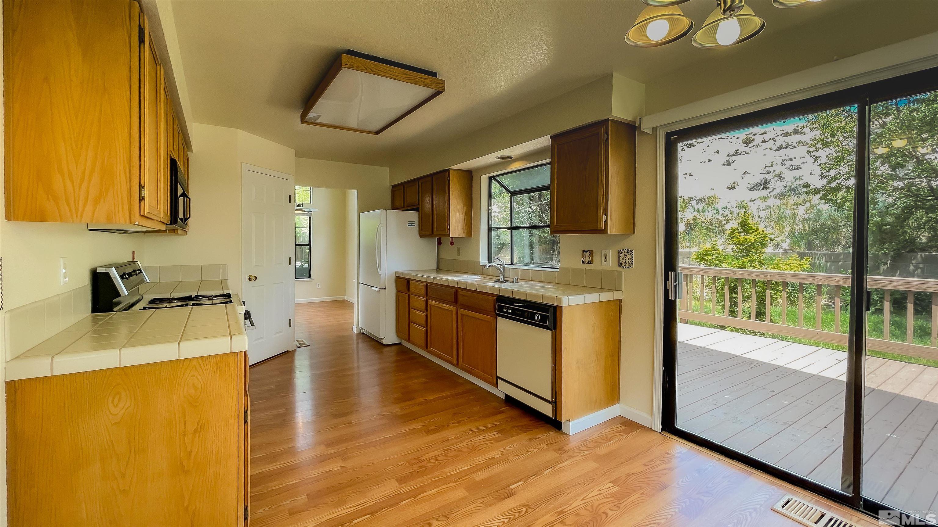 1710 Fox Run Road Reno, NV 89523 - Photo 7 of 28 a kitchen with stainless steel appliances granite countertop a stove a sink and a refrigerator