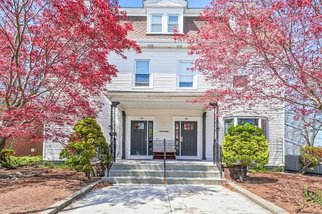 a view of a white house next to a yard