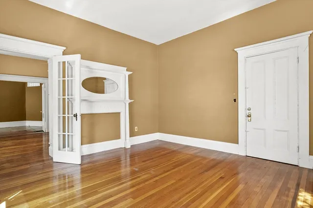 a view of an empty room with wooden floor