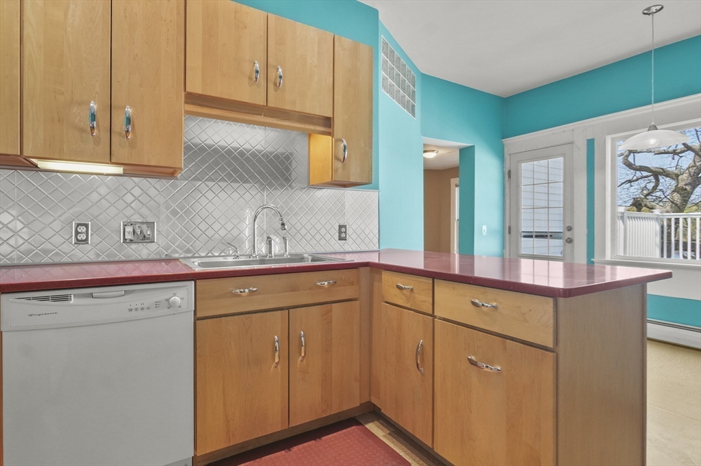55-57 Crescent Street Waltham, MA 02453 - Photo 13 of 37 a kitchen with stainless steel appliances granite countertop white cabinets and a sink