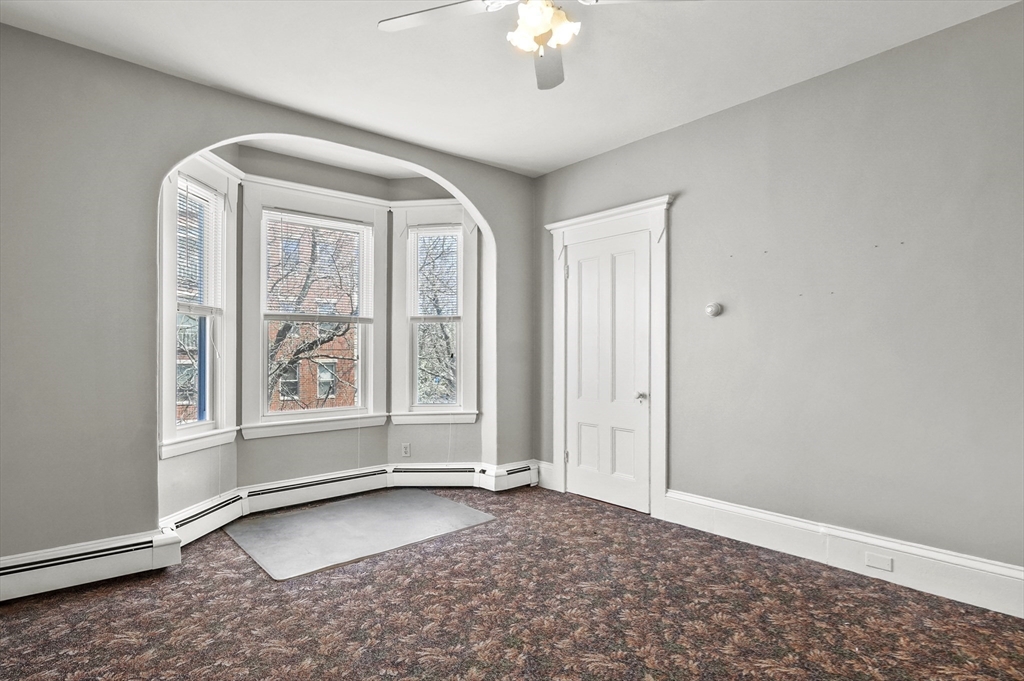 55-57 Crescent Street Waltham, MA 02453 - Photo 27 of 37 an empty room with windows and chandelier fan