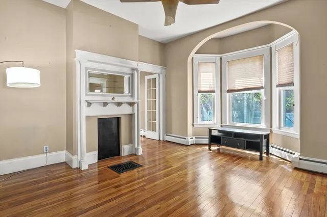 a view of empty room with wooden floor and fireplace