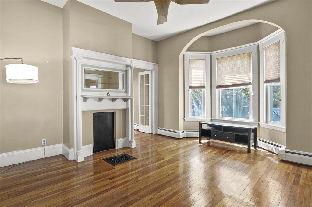 55-57 Crescent Street Waltham, MA 02453 - Photo 3 of 37 a view of empty room with wooden floor and fireplace