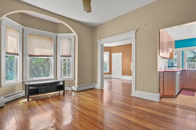 a living room with hardwood floor and a ceiling fan