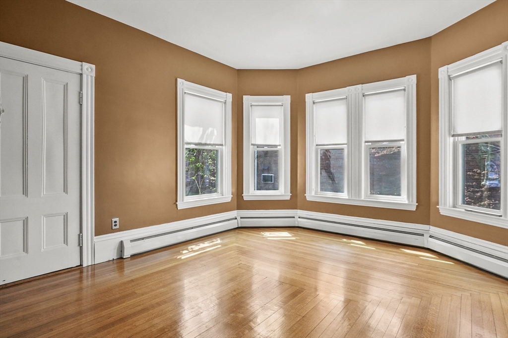 55-57 Crescent Street Waltham, MA 02453 - Photo 5 of 37 a view of an empty room with wooden floor and a window