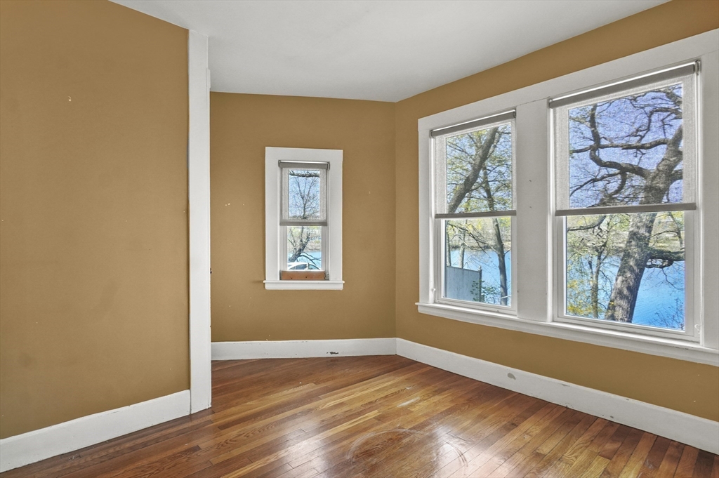55-57 Crescent Street Waltham, MA 02453 - Photo 9 of 37 a view of an empty room with wooden floor and a window