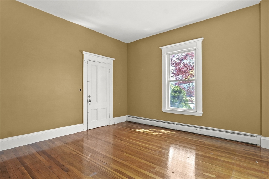 55-57 Crescent Street Waltham, MA 02453 - Photo 10 of 37 a view of an empty room with wooden floor and a window