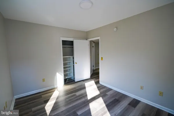 an empty room with wooden floor and white walls