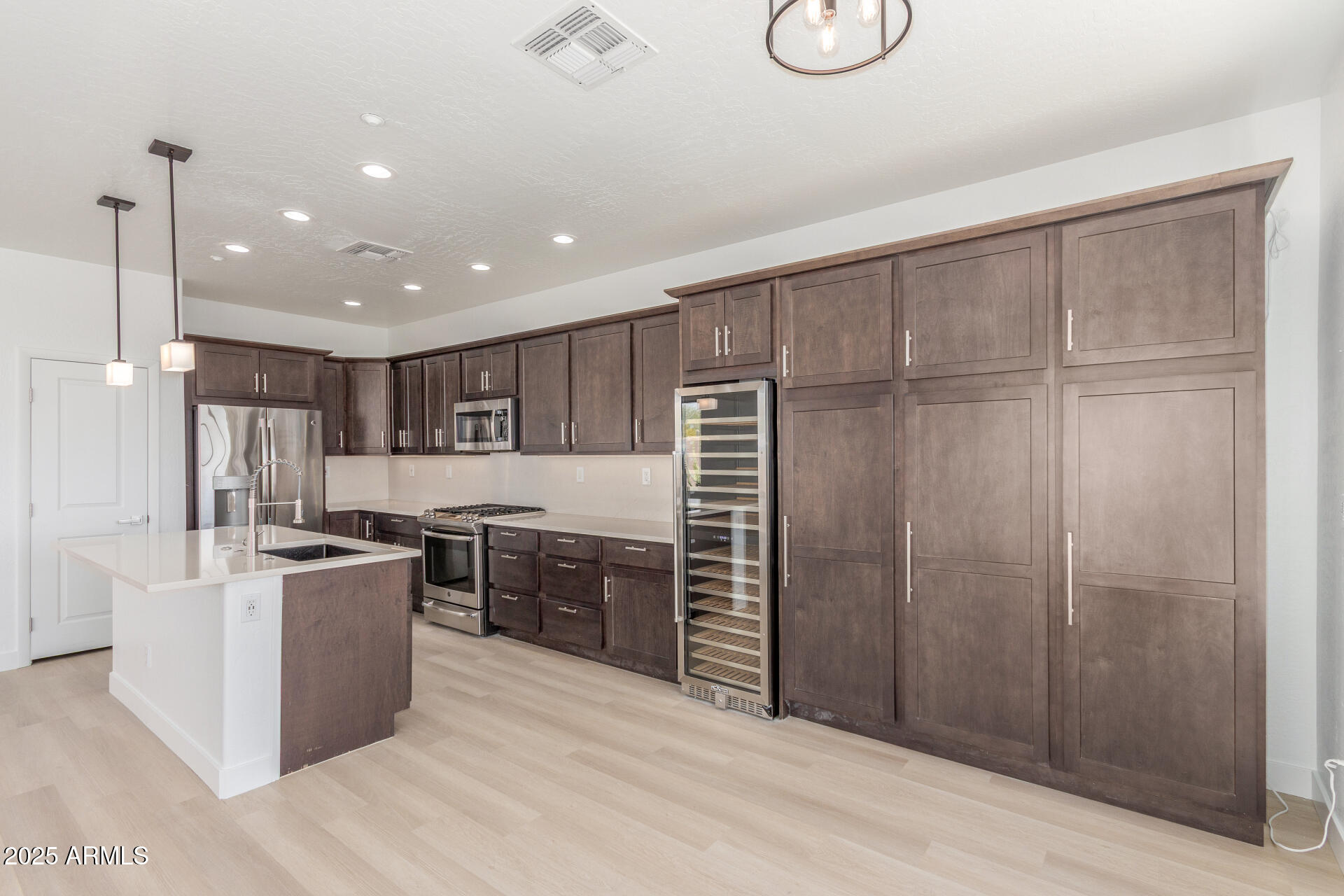 41401 North Maidstone Court Anthem, AZ 85086 - Photo 11 of 53 a kitchen with stainless steel appliances granite countertop a refrigerator a stove and a sink