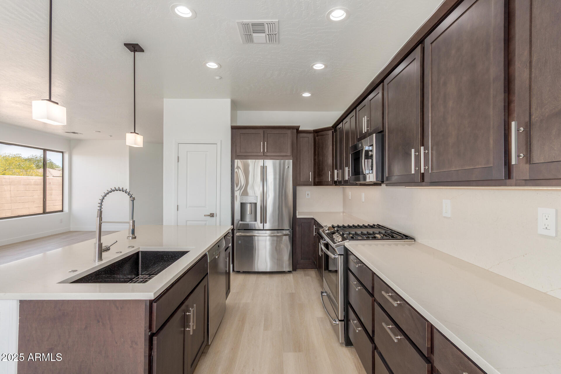 41401 North Maidstone Court Anthem, AZ 85086 - Photo 12 of 53 a kitchen with stainless steel appliances a sink stove and cabinets