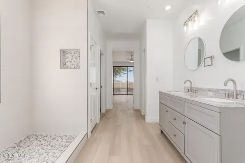 a spacious bathroom with a double vanity sink and mirror