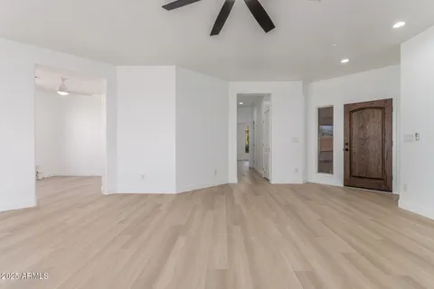 an empty room with ceiling fan and window