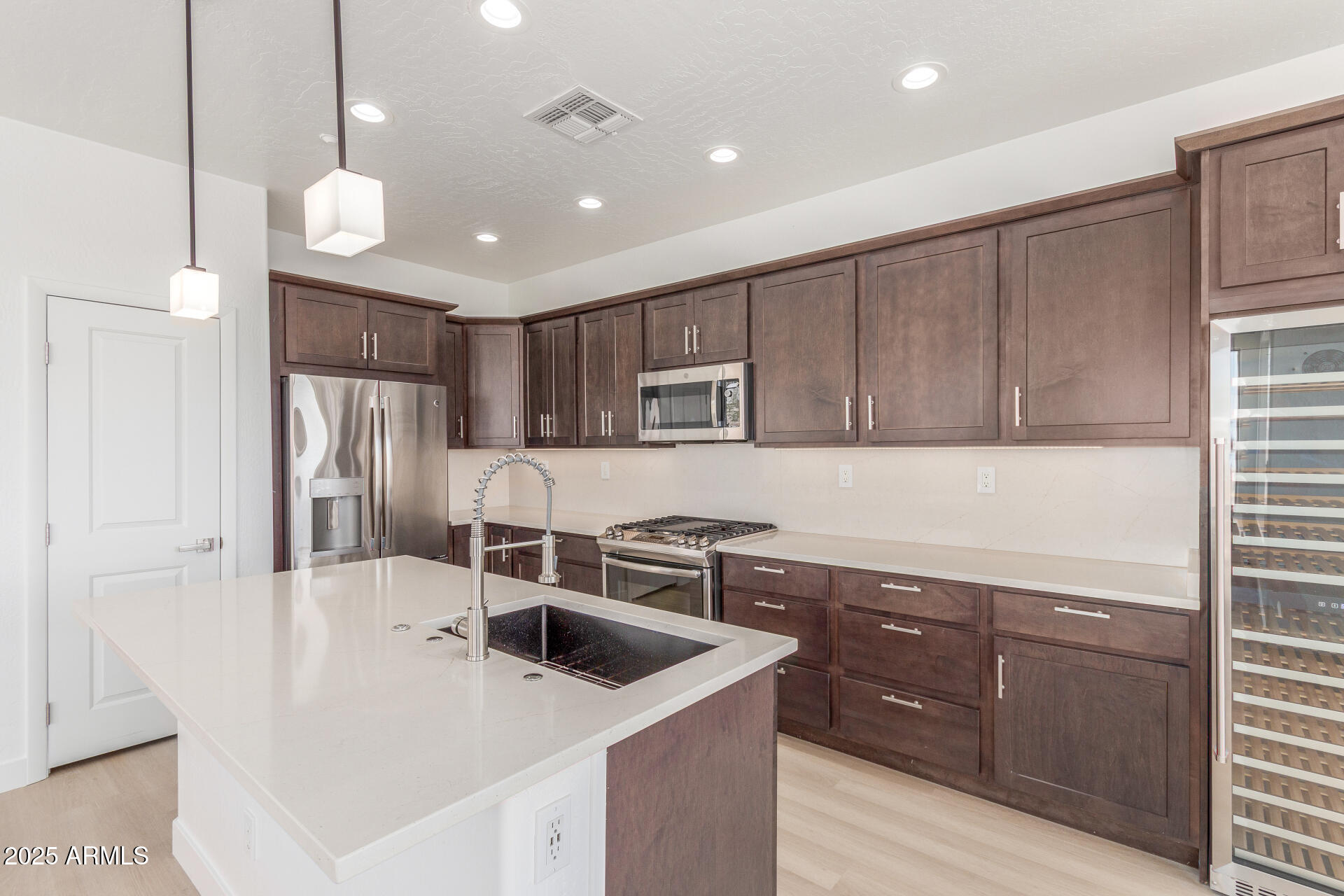 41401 North Maidstone Court Anthem, AZ 85086 - Photo 10 of 53 a kitchen with a sink a stove a refrigerator and cabinets