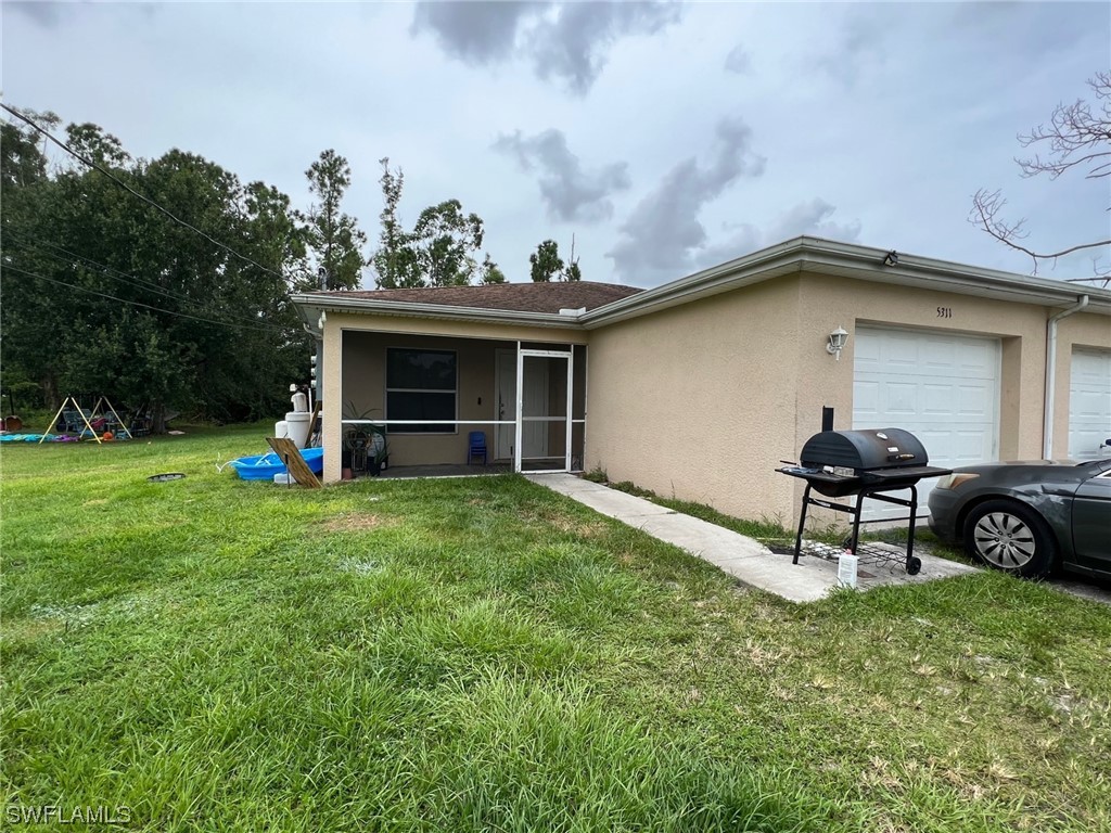 5311 Banning Street Lehigh Acres, FL 33971 - Photo 2 of 21 a backyard of a house with table and chairs