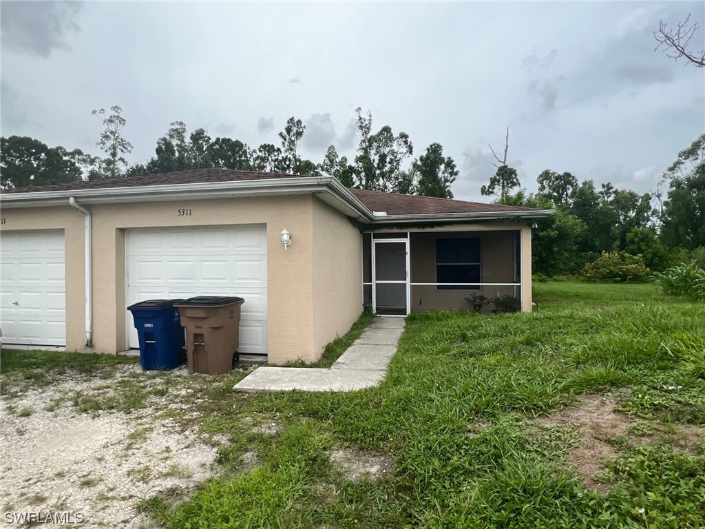 5311 Banning Street Lehigh Acres, FL 33971 - Photo 3 of 21 front view of a house with a yard