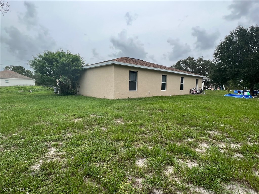 5311 Banning Street Lehigh Acres, FL 33971 - Photo 4 of 21 a front view of a house with garden