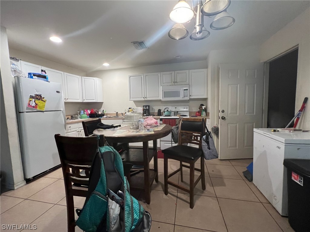 5311 Banning Street Lehigh Acres, FL 33971 - Photo 7 of 21 a kitchen with a dining table chairs and refrigerator