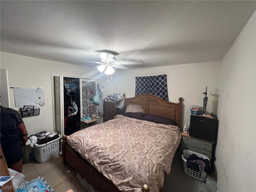 5311 Banning Street Lehigh Acres, FL 33971 - Photo 9 of 21 a bedroom with a bed and a chandelier