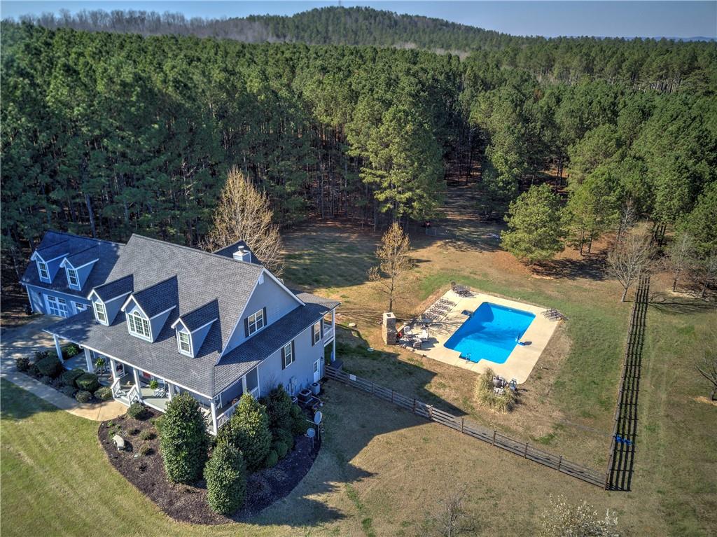 an aerial view of a house with pool lake view and mountain view