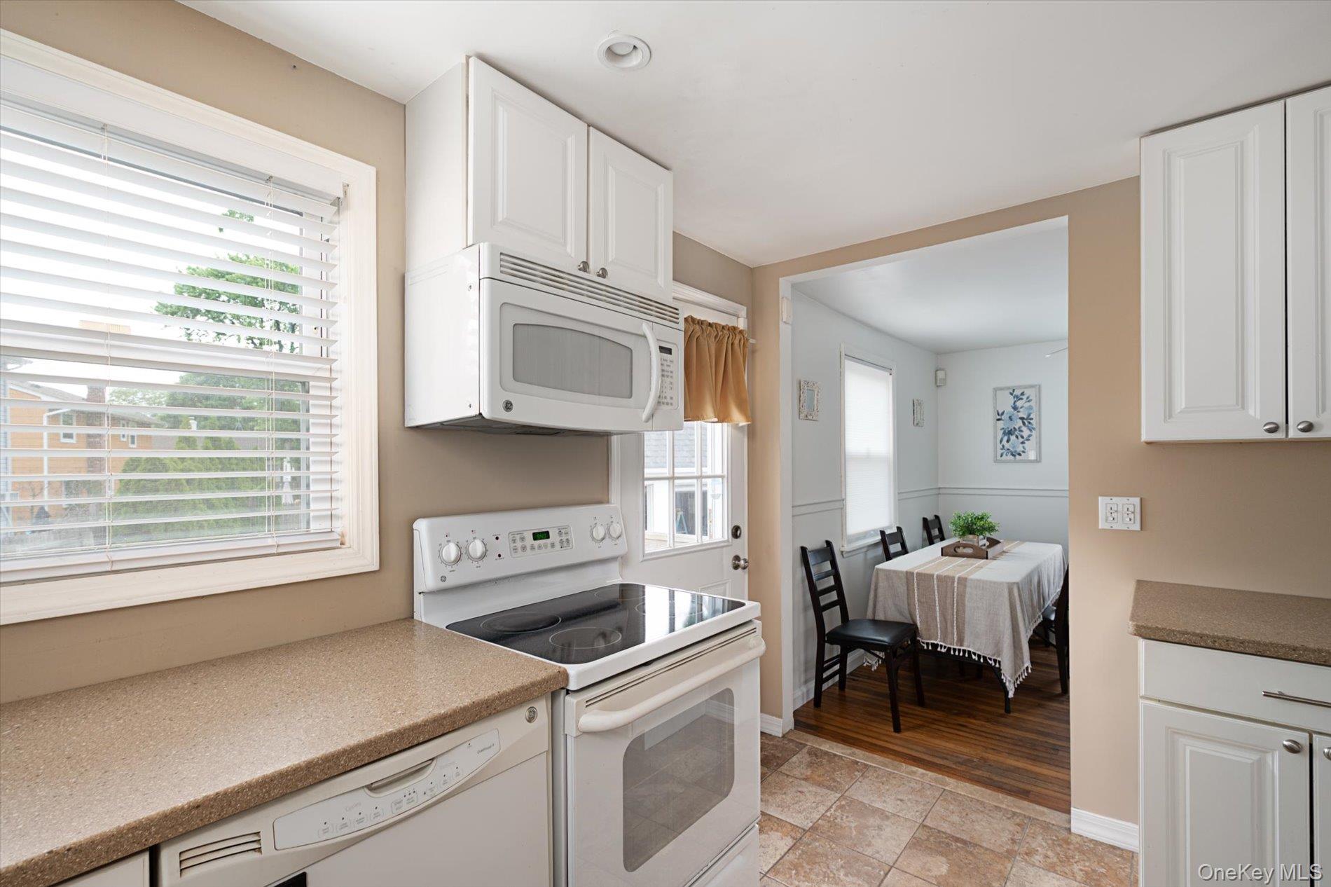 675 Little E Neck Road West Babylon, NY 11704 - Photo 8 of 20 a kitchen with stainless steel appliances a stove a sink and white cabinets