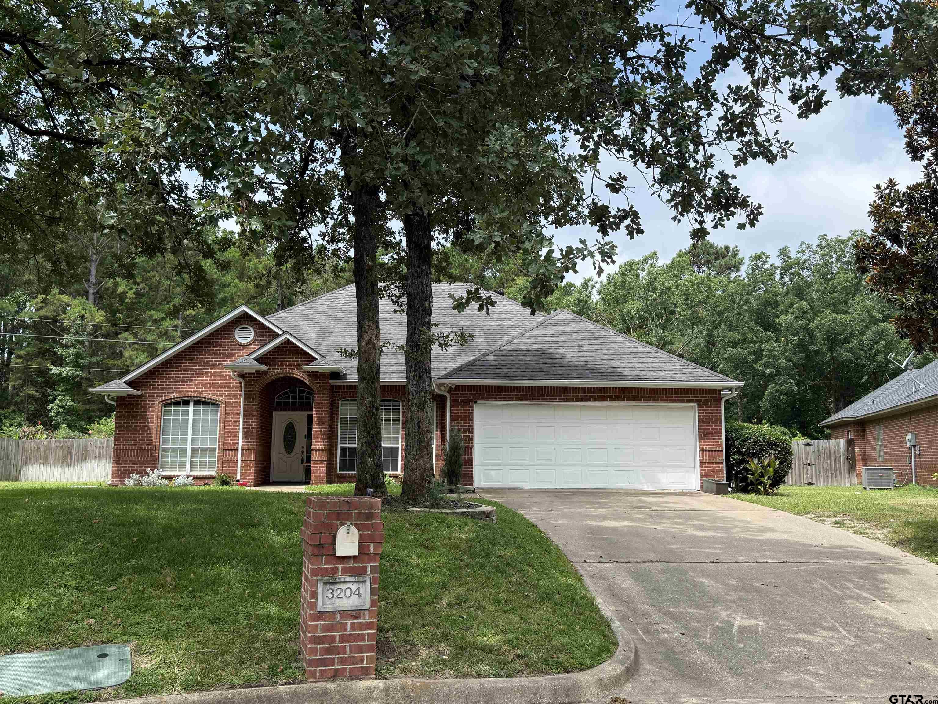 3204 Pebblebrook Circle Tyler, TX 75707 - Photo 1 of 18 a front view of a house with a yard and garage