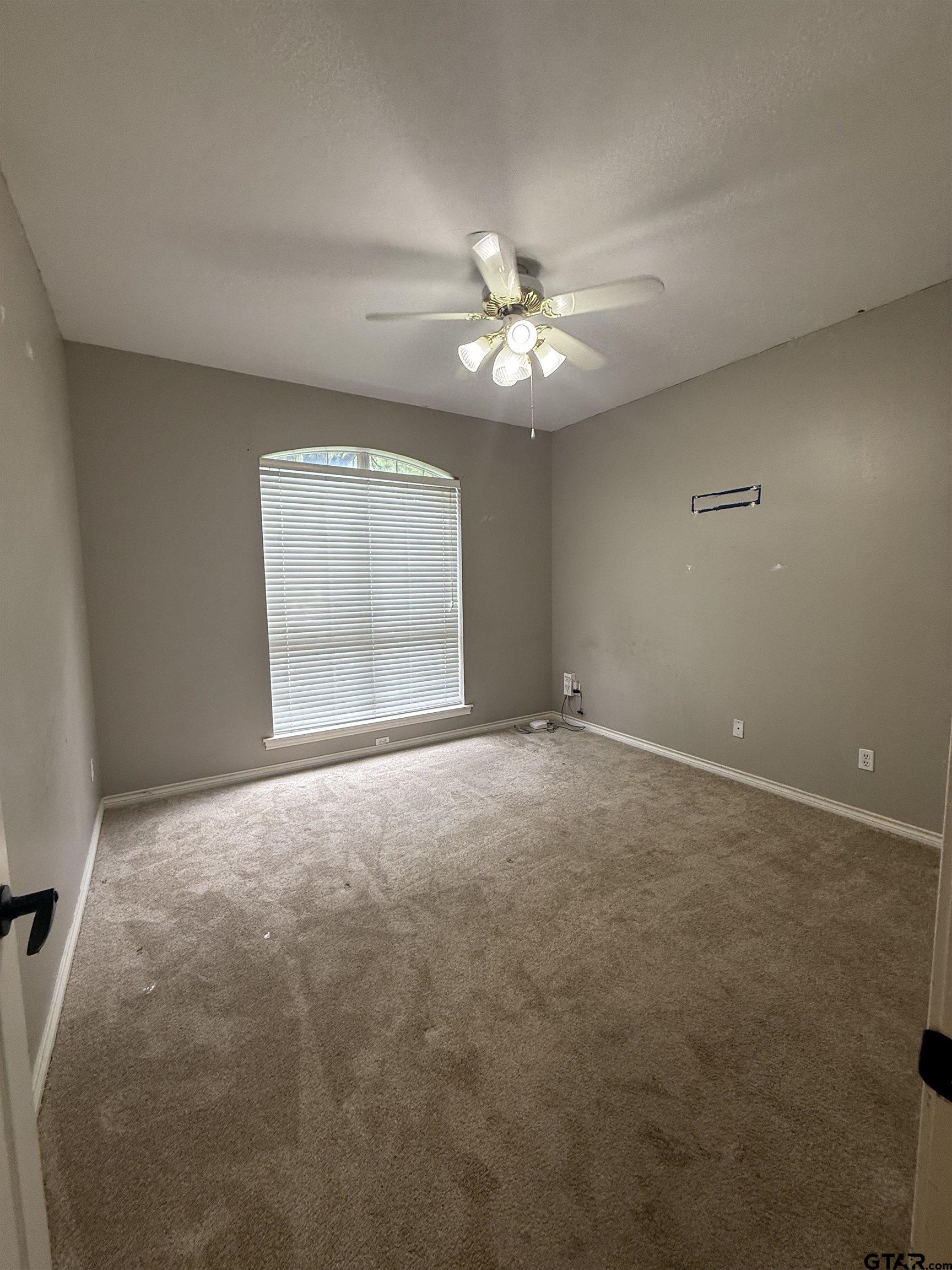 3204 Pebblebrook Circle Tyler, TX 75707 - Photo 11 of 18 en empty room with windows and ceiling fan