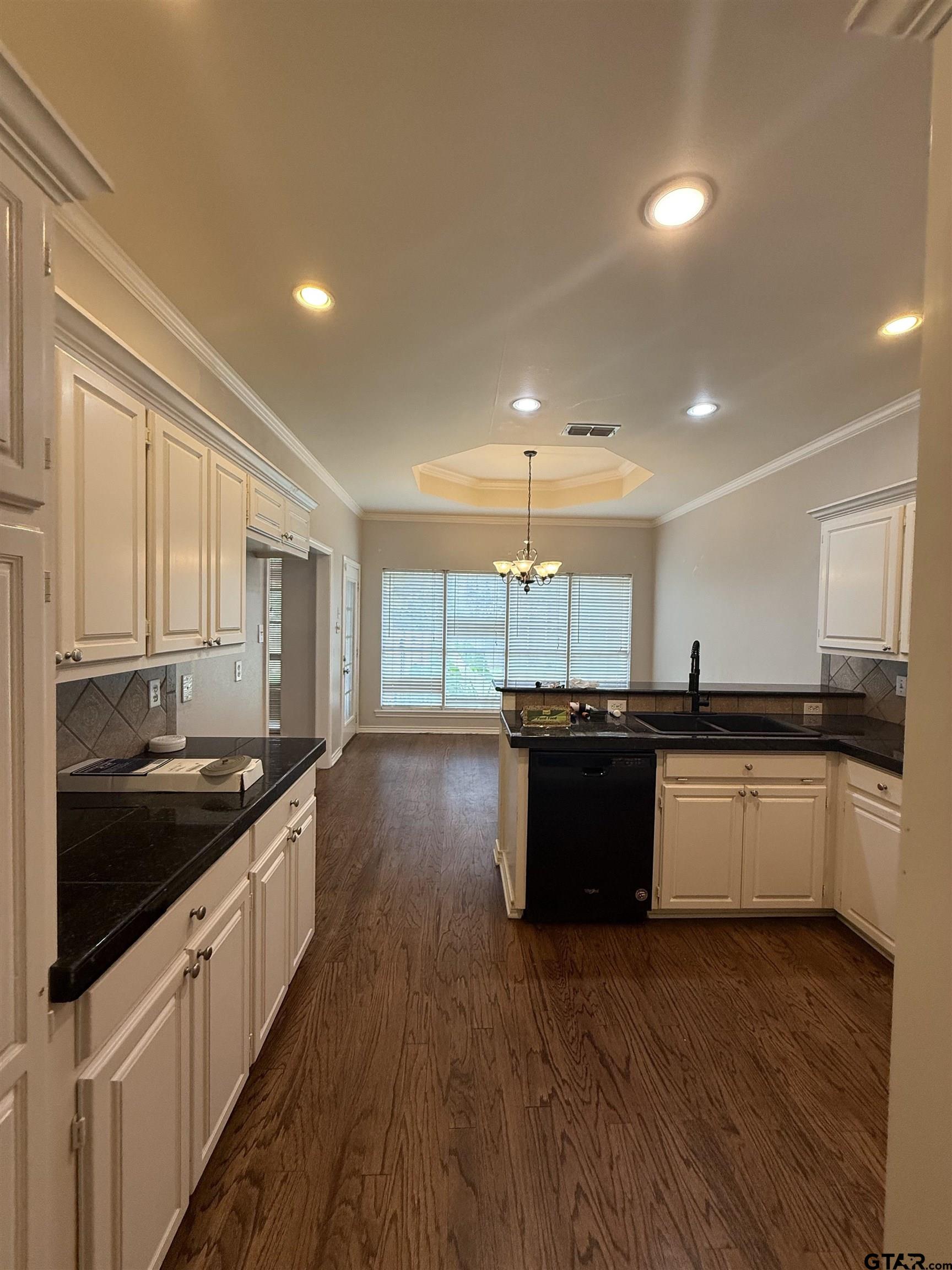 3204 Pebblebrook Circle Tyler, TX 75707 - Photo 2 of 18 a kitchen with a sink and wooden cabinets
