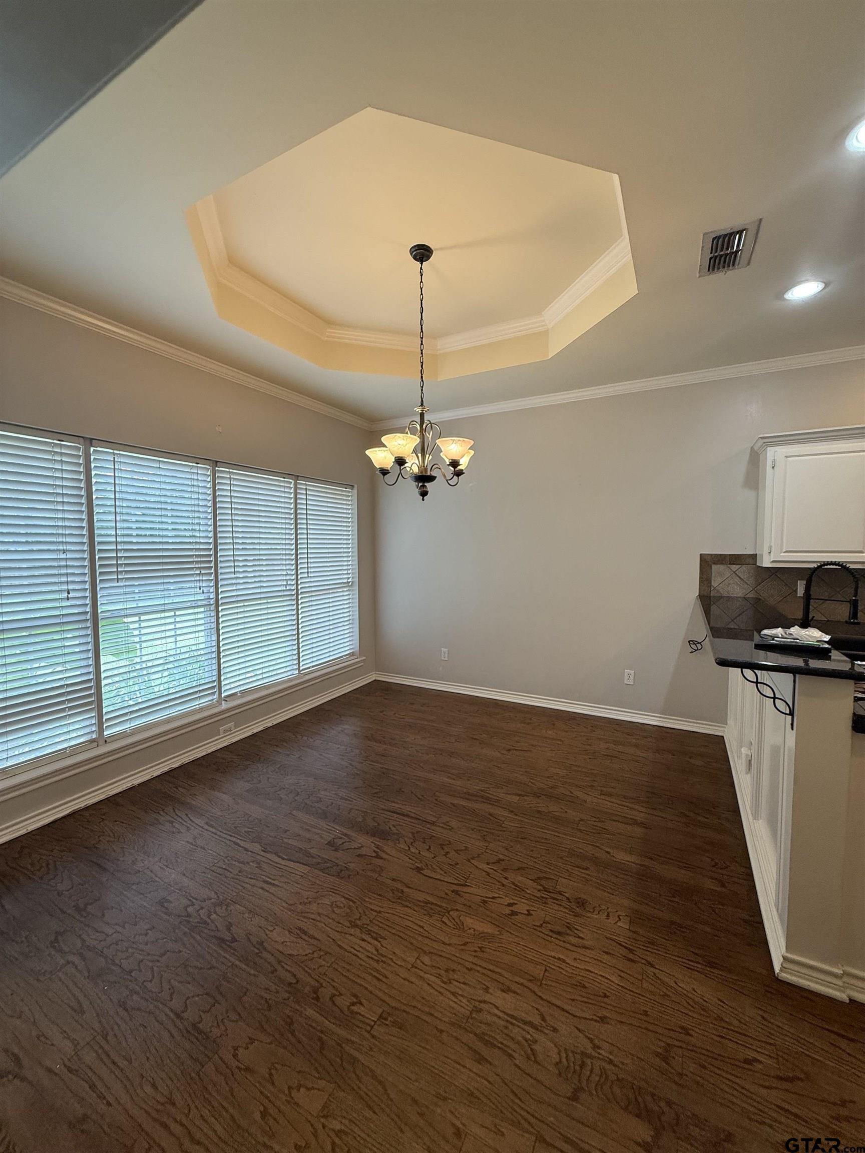 3204 Pebblebrook Circle Tyler, TX 75707 - Photo 4 of 18 a view of a room with wooden floor ceiling fan and windows