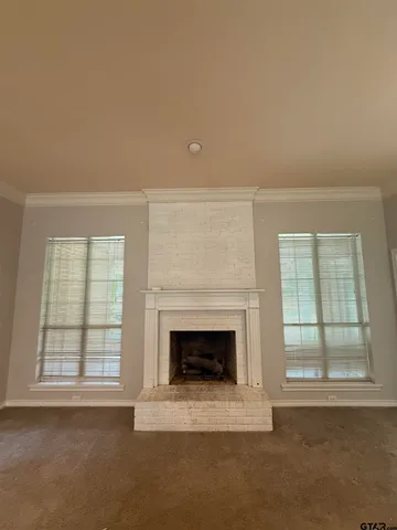 an empty room with windows and fireplace