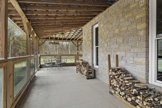 a kitchen with stainless steel appliances a dining table chairs refrigerator and microwave