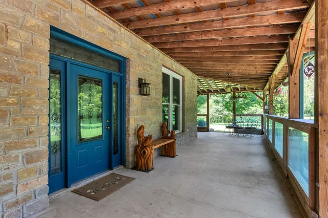 a view of a porch with a table and chairs