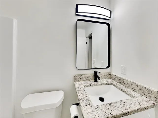 a bathroom with a toilet sink and mirror