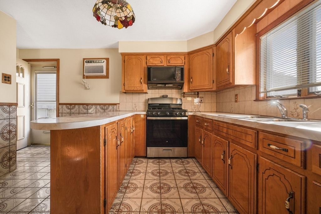 256 Rhode Island Avenue Fall River, MA 02724 - Photo 19 of 36 a kitchen with stainless steel appliances granite countertop a stove a sink and a microwave