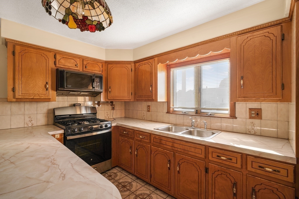 256 Rhode Island Avenue Fall River, MA 02724 - Photo 20 of 36 a kitchen with a sink stove and microwave
