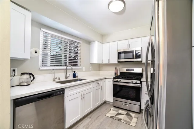 a kitchen with appliances a sink and a window