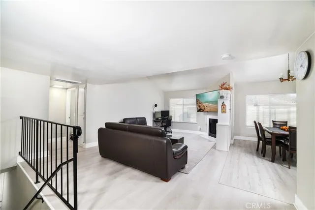 a living room with furniture and a dining table with kitchen view