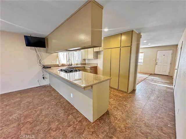 a kitchen with stainless steel appliances granite countertop a sink and a refrigerator