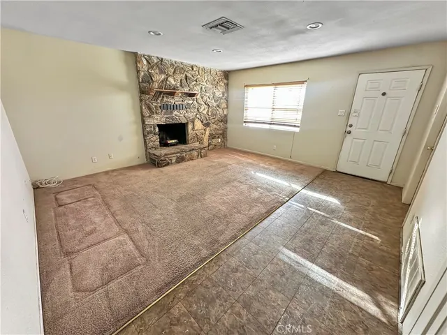 a view of empty room with fireplace and window