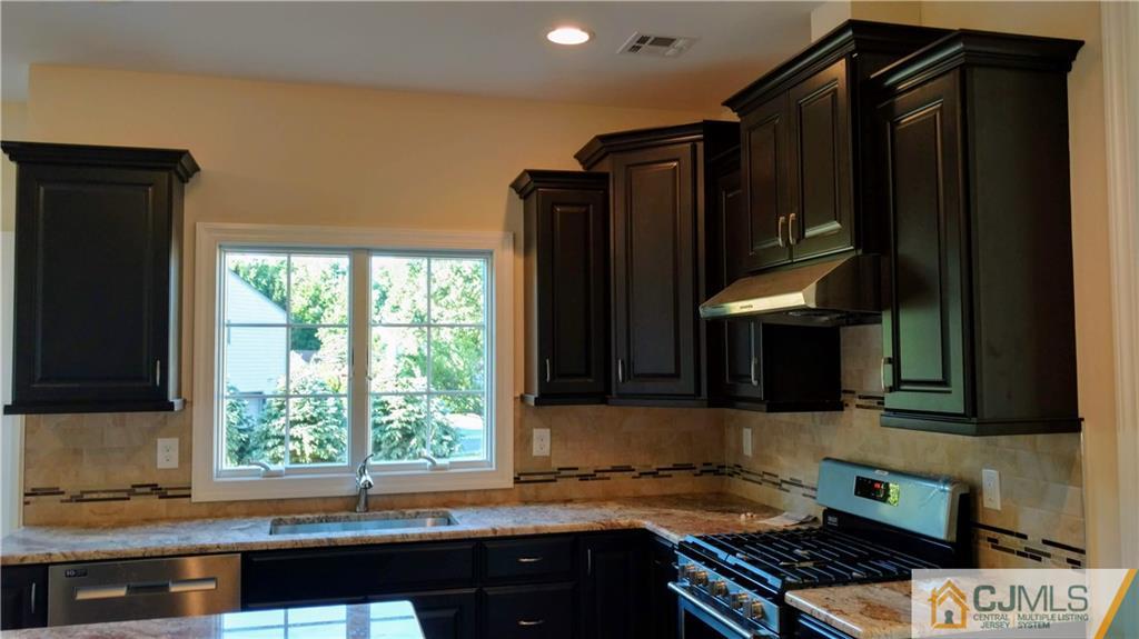2028 Oak Tree Road Edison, NJ 08820 - Photo 8 of 39 a kitchen with granite countertop a stove a sink and a microwave