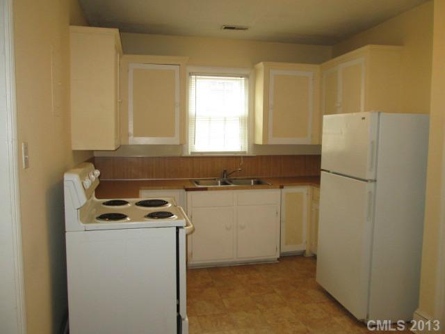 516 Grandin Road, Unit 3 Charlotte, NC 28208 - Photo 4 of 7 a kitchen with a refrigerator and white cabinets