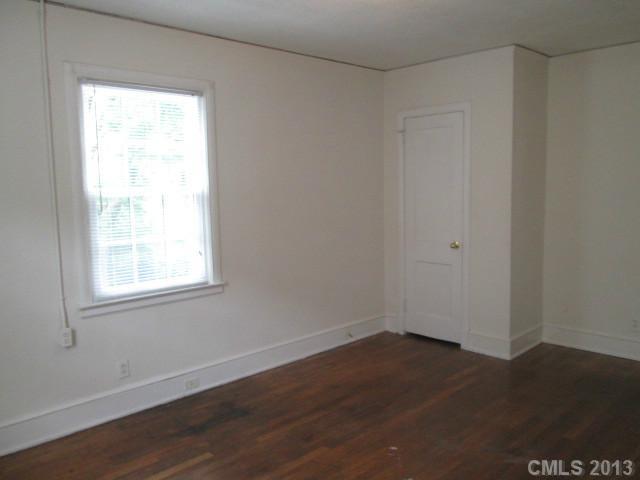 516 Grandin Road, Unit 3 Charlotte, NC 28208 - Photo 5 of 7 an empty room with wooden floor and windows