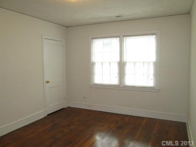 516 Grandin Road, Unit 3 Charlotte, NC 28208 - Photo 7 of 7 an empty room with wooden floor and windows