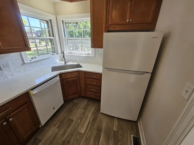 a kitchen with a sink a refrigerator a window and cabinets