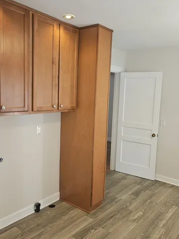 a view of an empty room with wooden floor and closet