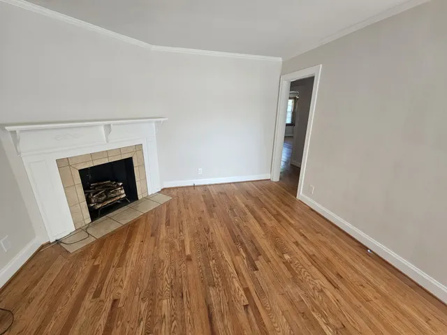 a view of empty room with wooden floor and fireplace