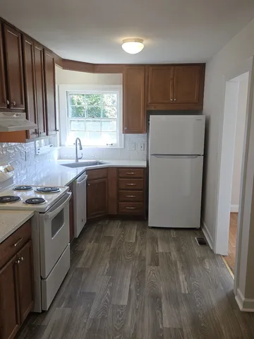 a kitchen with a sink a stove a refrigerator and a window