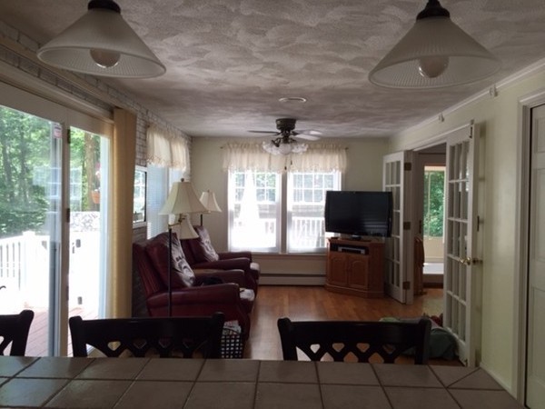 17 Virginia Road Tyngsborough, MA 01879 - Photo 2 of 19 a living room with furniture a flat screen tv and floor to ceiling window