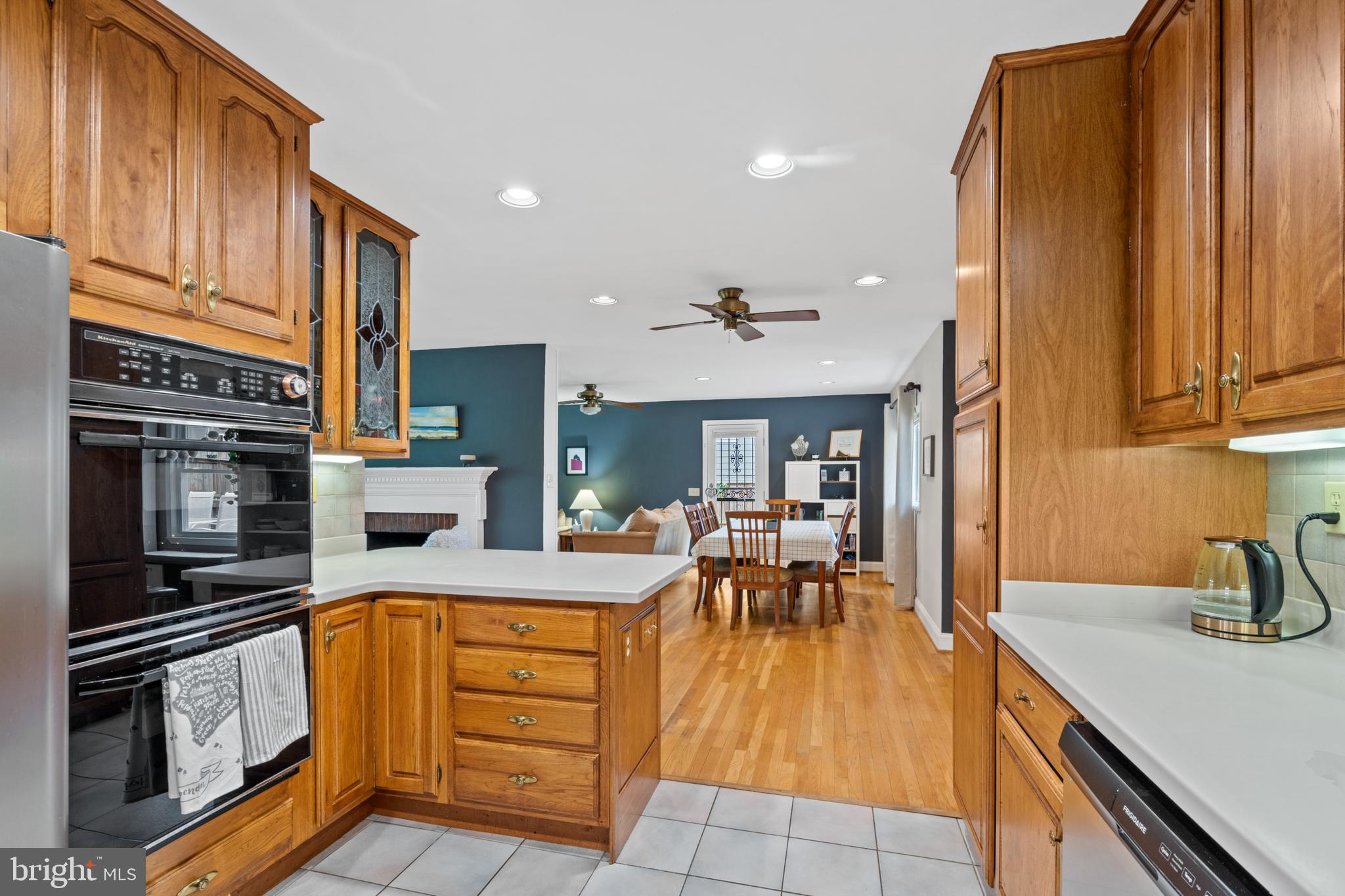 6823 Churchill Road McLean, VA 22101 - Photo 22 of 40 a kitchen with stainless steel appliances granite countertop a stove top oven a sink a dining table and chairs with wooden floor