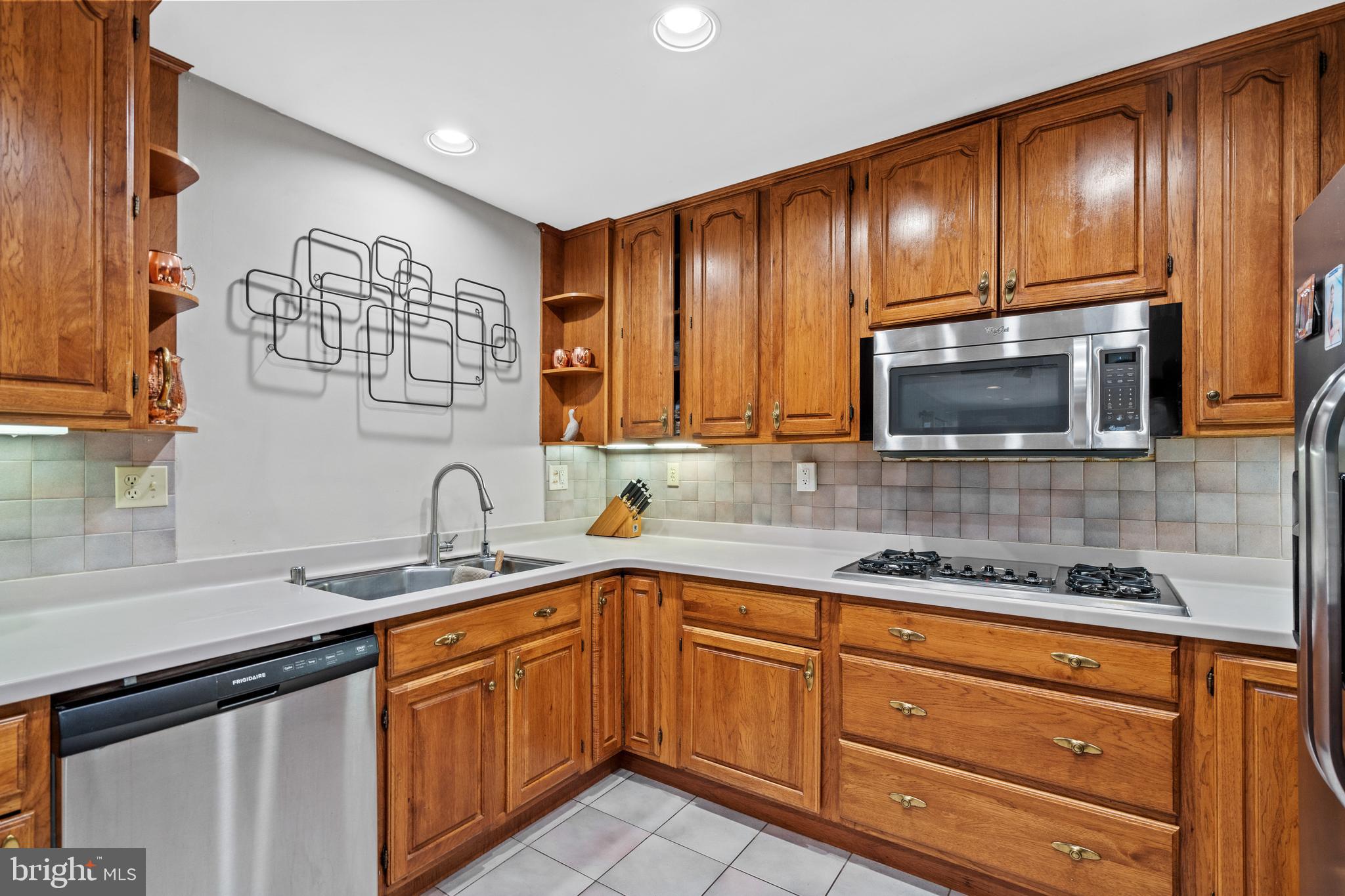 6823 Churchill Road McLean, VA 22101 - Photo 23 of 40 a kitchen with stainless steel appliances granite countertop a sink stove and microwave